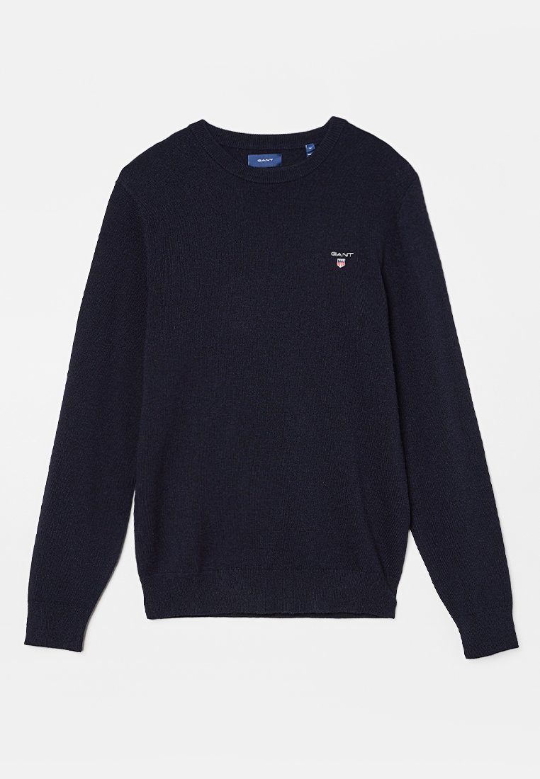 Dunkelblauer Strickpullover mit langen Ärmeln und Rundhalsausschnitt. Verfügt über ein kleines gesticktes Logo auf der Brust. Weiche Textur und normale Passform.