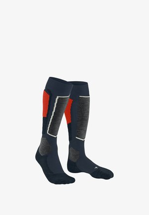 Calzini alti fino al ginocchio di colore blu navy con motivi geometrici rossi e grigi, con cima a costine e rinforzo per la punta e il tallone per una maggiore durata.