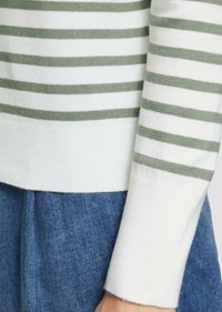 Gestreifter Pullover mit weichen weißen und salbeigrünen horizontalen Streifen, gerippten Bündchen und einer gemütlichen Strickstruktur. Kombiniert mit Denim-Stoff.