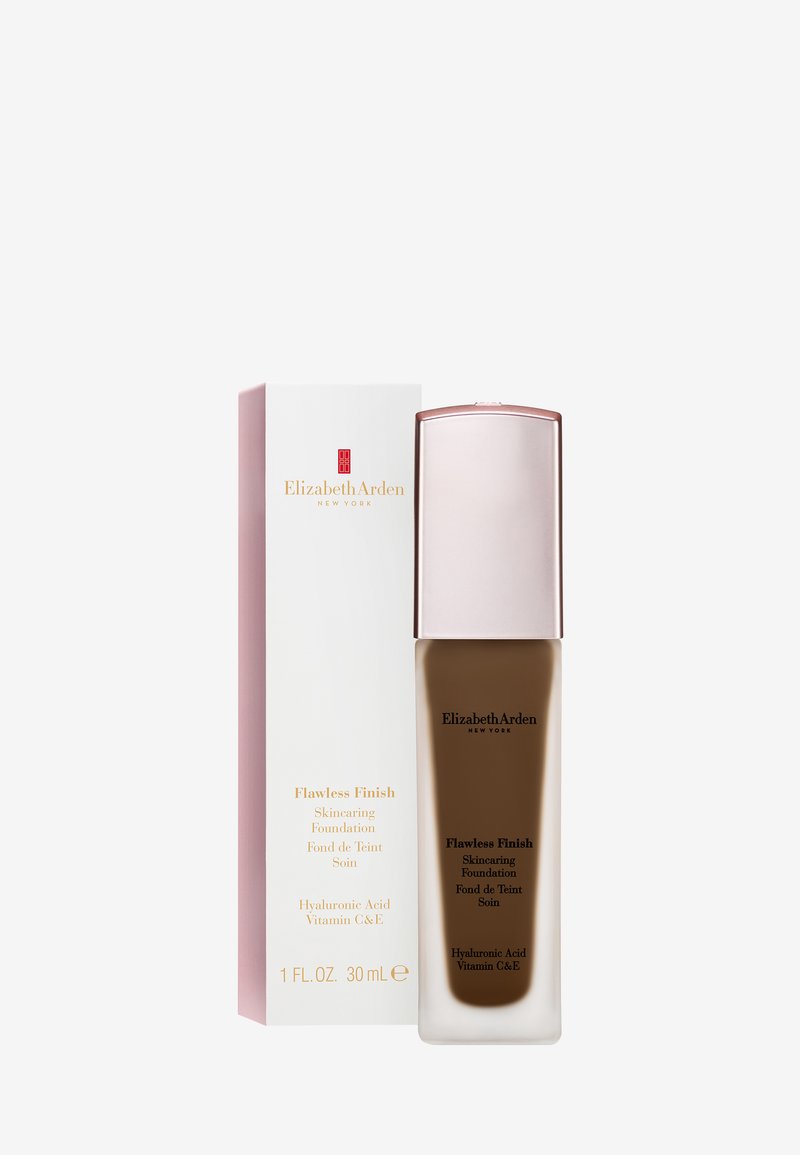 Flacon de fond de teint Elizabeth Arden Flawless Finish et boîte blanche avec marquage doré et rouge et détails du produit sur fond blanc.