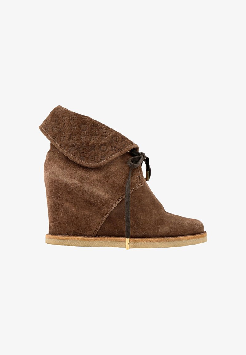 Bottine compensée en daim marron avec revers plié présentant un motif embossé et lacets avant avec embouts dorés, semelle plate beige.