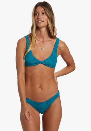 Teal ribbat bikini med djup urringning, breda remmar och matchande låg midja med subtil textur och mönsterdetaljer.