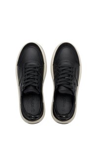 Černé kožené tenisky s hladkým povrchem, šněrováním, zaoblenou špičkou a krémovou gumovou podrážkou. Perforované detaily na svršku.