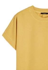 Żółta koszulka z okrągłym dekoltem, wykonana z miękkiego materiału, z krótkimi rękawami. Posiada prosty design i ribbowany dekolt. Brak wzorów lub akcentów.