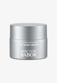 Conteneur argenté avec une finition lisse ; étiqueté "LA CRÈME DE GUÉRISON" et "DOCTOR BABOR." Contient 15 % d'extrait de plante Biogen. Forme ronde.