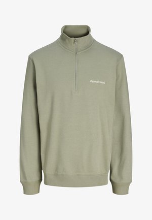 Φωτεινό πράσινο φούτερ με φερμουάρ στο ένα τέταρτο, μακριά μανίκια, ριμπ μανσέτες και τελείωμα, και μικρό λευκό κείμενο "Originals Studios" στο στήθος.