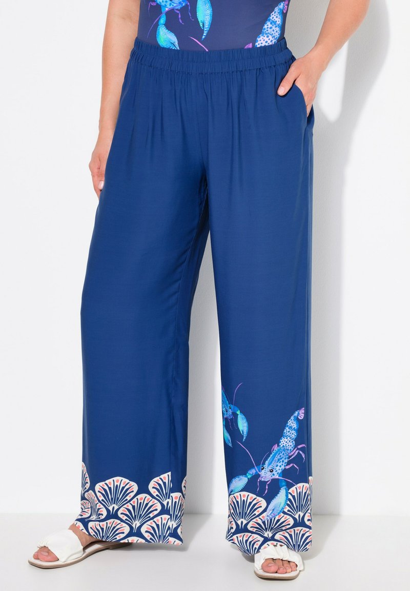 Námořnické široké kalhoty vyrobené z lehkého materiálu, s barevnými potisky humrů a ozdobným lemem vzoru mušlí. Elastický pás pro pohodlí.