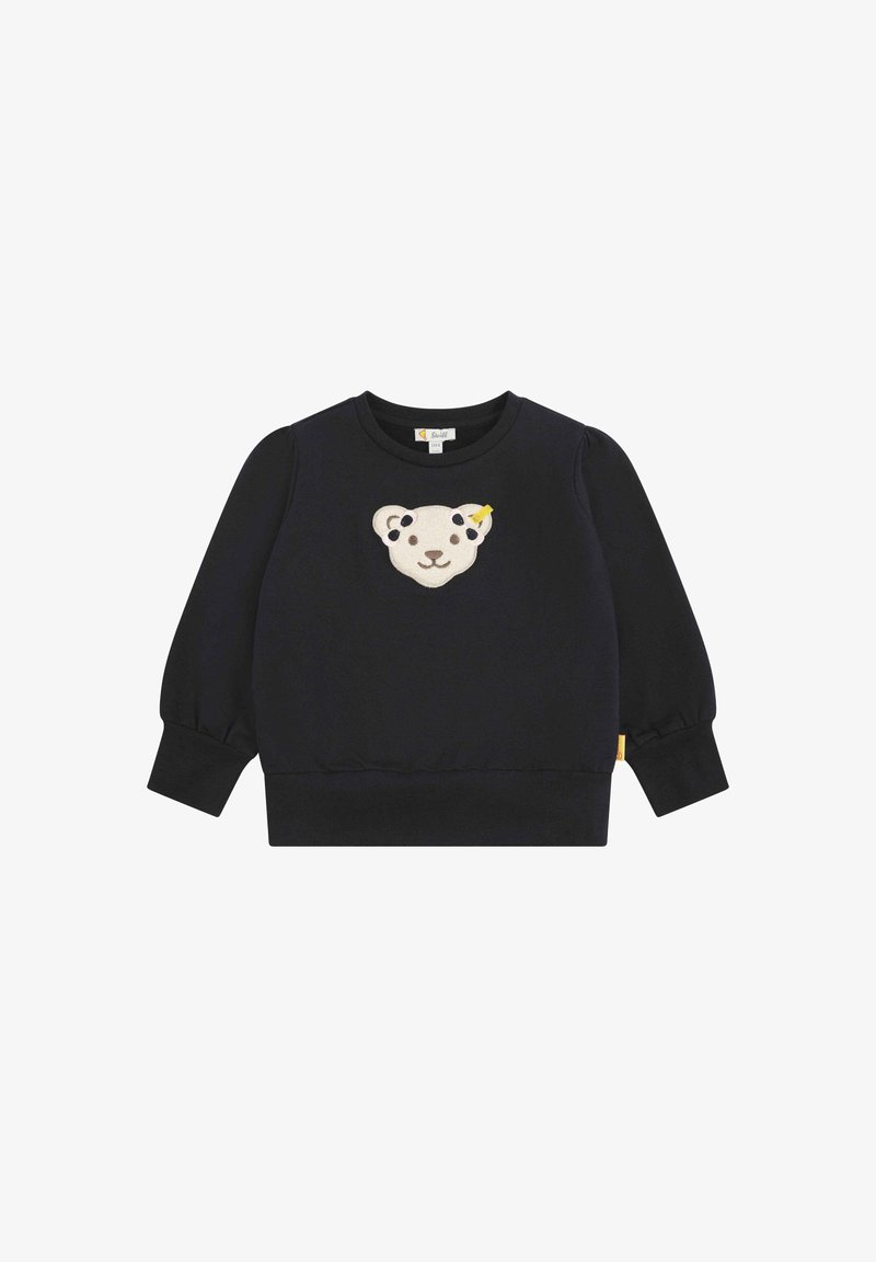 Sudadera negra con mangas abullonadas, que presenta un aplique en forma de cara de oso en crema y amarillo en la parte delantera y una etiqueta de logo en el lateral.