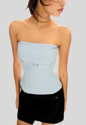 Lichtblauwe strapless top met verticale witte strepen, aansluitend ontwerp en zilveren hardware accent bij de taille. In combinatie met een zwarte rok.