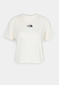 Krämfärgad T-shirt med kort ärm i mjukt tyg. Har en liten svart logotyp på vänster bröst och en avslappnad passform.
