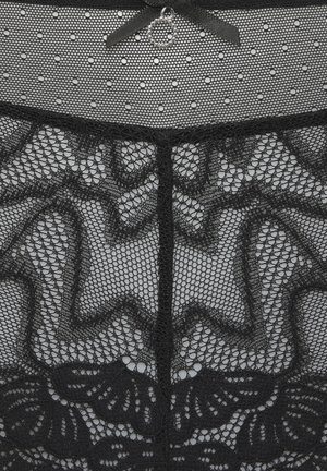 Tessuto di pizzo nero trasparente con motivi floreali e bordi smerlati, parte superiore in rete a pois e un piccolo fiocco decorativo con un charm circolare.