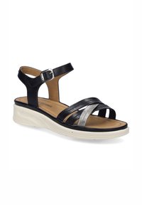 Czarno-metaliczne srebrne skórzane sandały z wieloma paskami, regulowanym zapięciem na kostce i białą, wyściełaną podeszwą. Płaska konstrukcja obcasa.