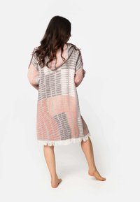 Kapský, stredne dlhý plášť z jemnej, ľahkej látky. Obsahuje viacfarebný vzor v odtieňoch ružovej, šedej a bielej s strapcami na leme.