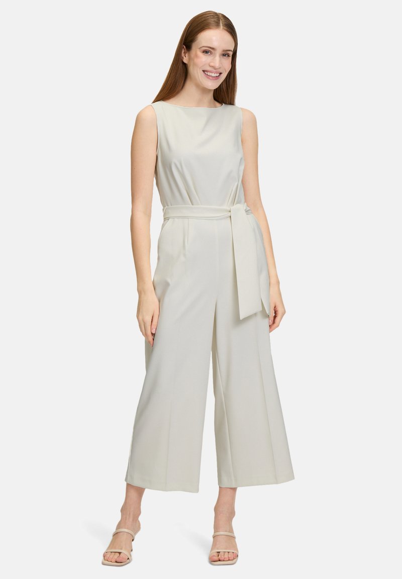 Jumpsuit senza maniche di un grigio chiaro, con un design a gamba larga e una cintura annodata in vita. Realizzato in tessuto liscio, presenta una silhouette semplice e pulita.
