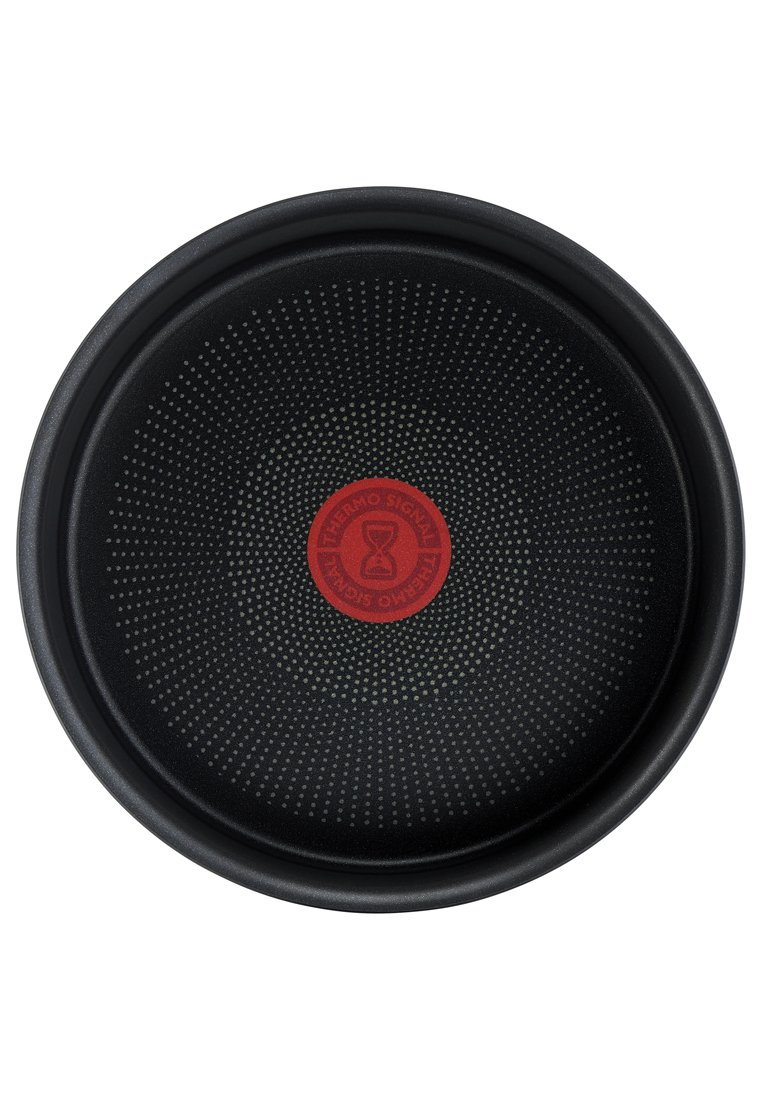 Schwarze antihaftbeschichtete Bratpfanne mit kreisförmigem Punktmuster und rotem Temperaturindikator-Kreis in der Mitte, auf dem "Thermo Signal" steht.