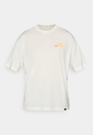 T-shirt bianco a maniche corte realizzato in tessuto morbido, con una grafica del logo arancione sul lato sinistro del petto e polsini a contrasto.