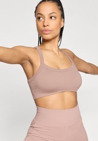 Ριμπ αθλητικό σουτιέν σε απαλό μοβ με φαρδιές τιράντες και cropped σχεδιασμό, με απαλό τελείωμα χωρίς ραφές και λεία υφή για άνεση.