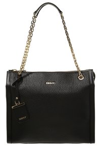 Svart texturerad läderhandväska från DKNY med guldkedjor och dragkedjestängning, med en liten matchande tag som hänger på sidan.