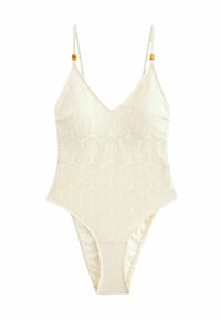 Maillot de bain crème avec un motif géométrique. Présente des bretelles fines et des accents en perles en bois. Design en V avec des jambes haute couture et un tissu texturé.