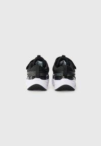 Schwarze Sportschuhe mit weißen Sohlen, ausgestattet mit einer glatten Ferse, gepolstertem Knöchelstütze und einem strukturierten Mesh-Obermaterial. Mit einem Griffschlaufen für einfaches Anziehen.