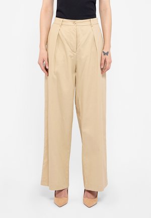 Pantaloni largi bej cu pliuri frontale, realizați din bumbac, cu o textură netedă, sistem de închidere cu nasturi frontal și detalii de cusătură.