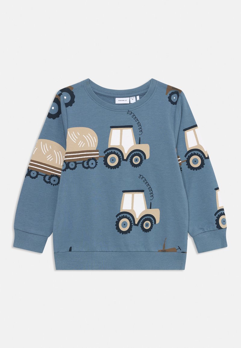 Sweatshirt azul com padrões de tratores e fardos de palha em bege e preto. Gola redonda e punhos canelados. Material de algodão macio.