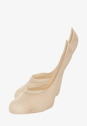 Beige ballettsko med en glatt tekstur, runde tær og uttalt bak-støtte. Har et dekorativt elastisk bånd over foten.