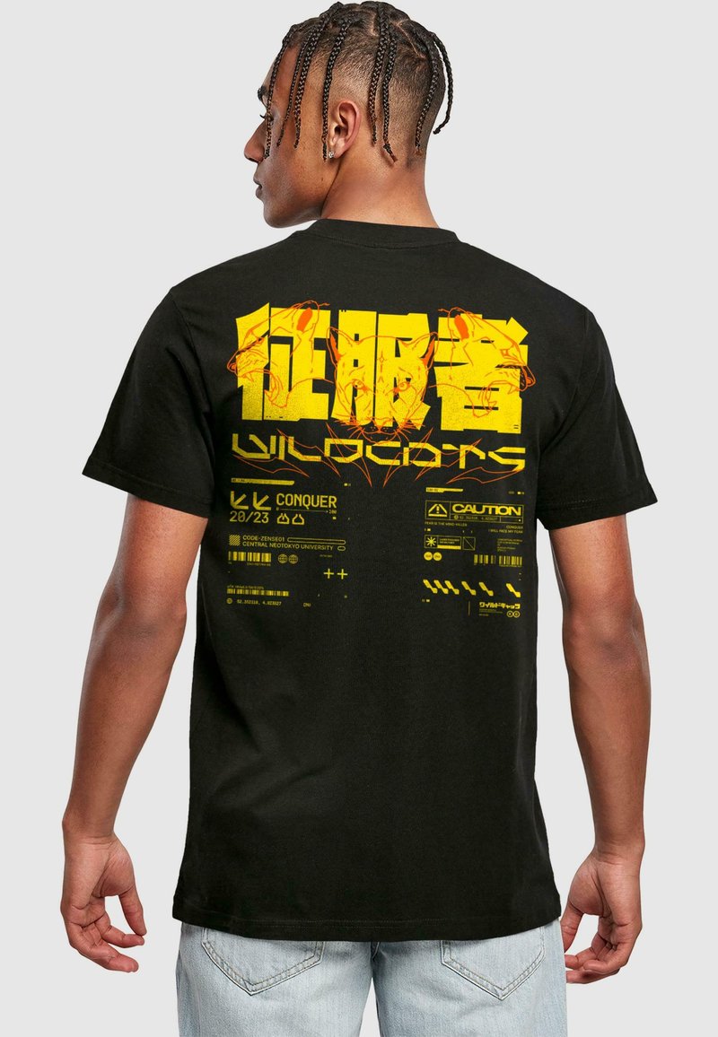 Sort bomulds T-shirt med et stort gult grafisk print på ryggen, der inkluderer tekst og abstrakte designs med advarselsymboler.