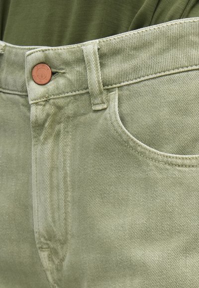 Ανοιχτό πράσινο τζιν παντελόνι με μπροστινές τσέπες, ορατό κουμπί και αντίθετη ραφή. Το ύφασμα έχει ελαφρώς υφή.