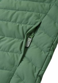 Zielona pikowana kurtka z zamkniętą kieszenią. Gładka, wyściółkowana tekstura z poziomymi szwami i dopasowanym zielonym zamkiem błyskawicznym.