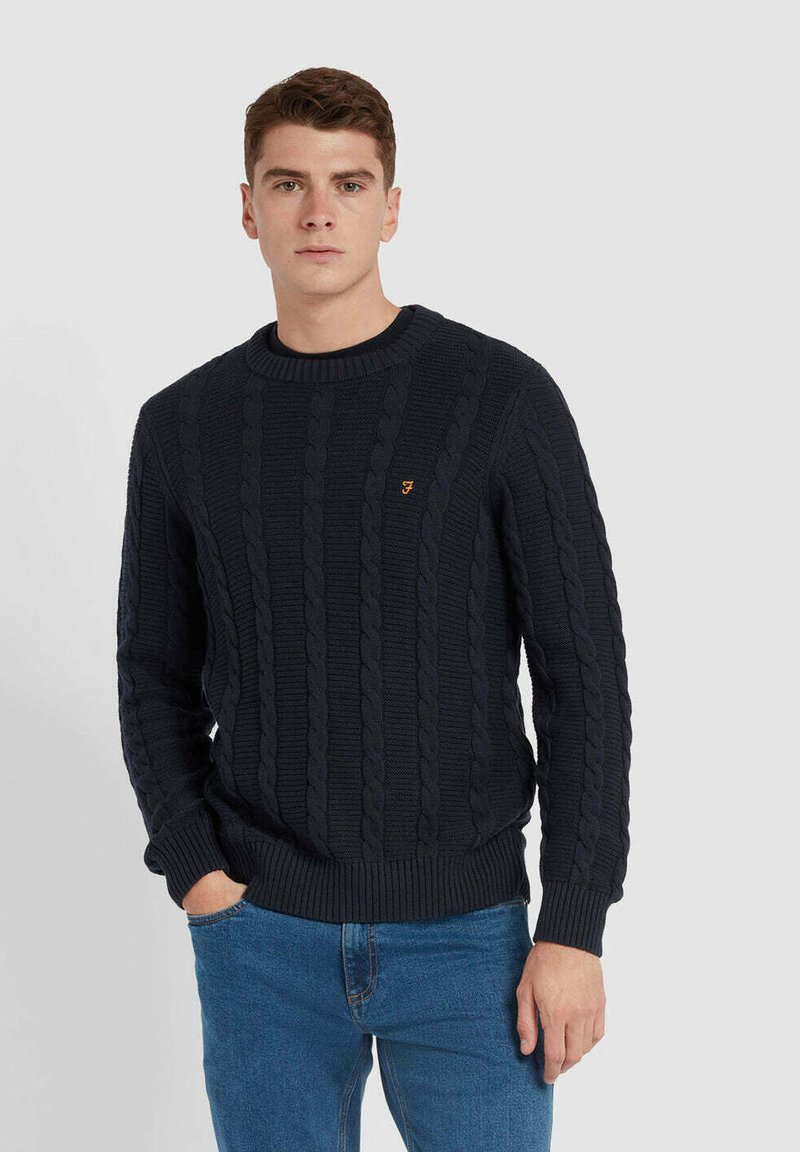 Navy kabelgebreide trui met geribde ronde hals, voorzien van een klein oranje logo op de borst en gestructureerde patronen door de hele trui.