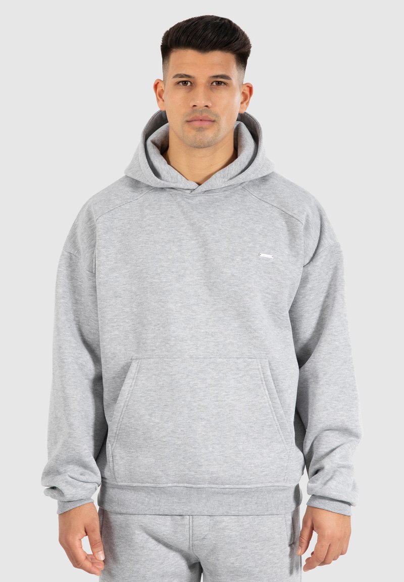 Grau Hoodie mit einer Vordertasche, gerippten Bündchen und Saum. Verfügt über ein kleines Logo auf der Brust und besteht aus weichem, strukturiertem Stoff.
