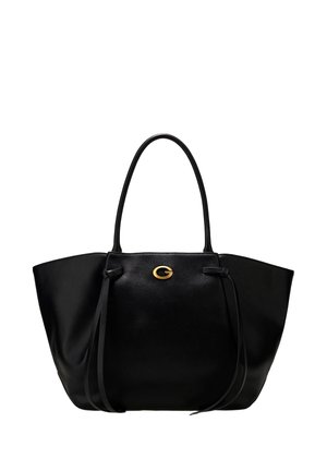Sac cabas en cuir noir avec longues anses, liens latéraux et un petit emblème doré centré près du haut devant.