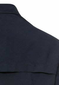 Kragen eines navyblauen Shirts mit glatter Textur, ausgestattet mit einem Detail am Rückenteil und sauberem Nähen. Klassisches Design ohne Verzierungen.