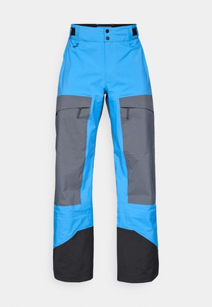 Blauwe en grijze waterdichte broek met een rechte snit, voorzien van ritszakken, contrasterende kleuren en een zwarte onderzoom.