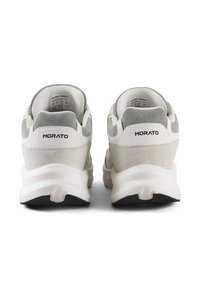 Witte en grijze sneakers met een mix van suède en leer. Dikke zool met een gebogen ontwerp, met de merknaam "MORATO" op de achterkant.