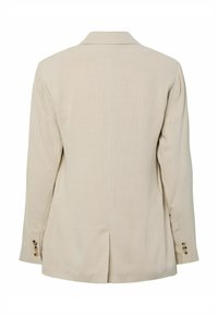 Blazer beige à manches longues avec une fente arrière et des détails de boutons aux poignets, présenté de dos sur un fond blanc.