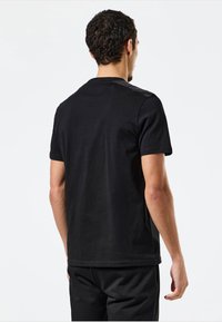 Sort kortærmet t-shirt lavet af bomuld, med et enkelt design, rund halsudskæring og en glat tekstur. Ingen bemærkelsesværdige mønstre eller grafik.