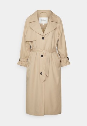 Trench-coat long beige avec larges revers, trois boutons noirs, ceinture à la taille et détails de boucle sur les poignets.