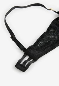 Crni čipkasti bralet s podesivim trakama. Sadrži meki materijal, složene čipkaste detalje i zatvaranje na tri kukice straga.