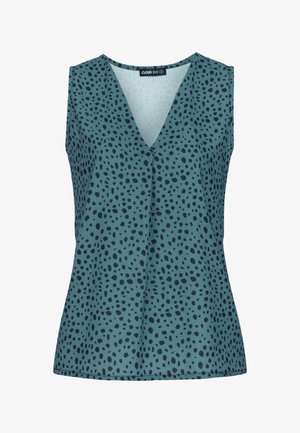 Top brez rokavov iz tičastega materiala z v-padlim izrezom, ki ima skozi celo tkanino črn pikast vzorec, nudi sproščen kroj in gladko teksturo.