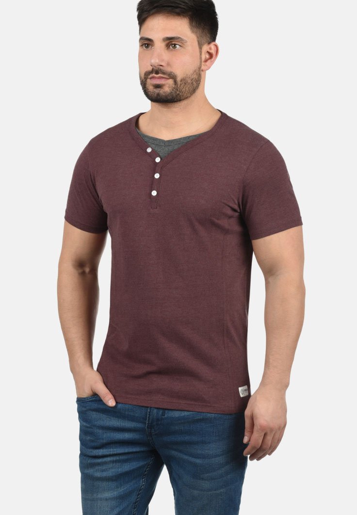 Burgunderfarget kortermet henley t-skjorte med v-hals, med tre hvite knapper og detalj av grått inne i kragen, laget av myk stoff.