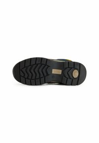 Czarna gumowa podeszwa z głębokim bieżnikiem, z beżową śródpodeszwą i oznaczeniem marki. Projekt jest praktyczny pod względem przyczepności i trwałości.