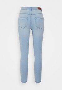 Jeans skinny de denim azul claro com uma cintura média, com dois bolsos traseiros e um rótulo de marca em couro na cintura.