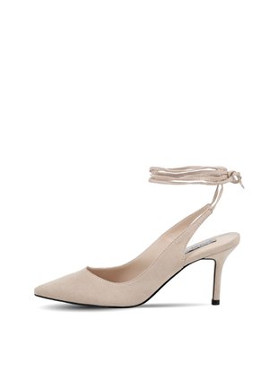 Scarpa con tacco alto in suede beige, con punta affusolata, design slingback e dettaglio con lacci alla caviglia. Tacco stiletto sottile e interno liscia.