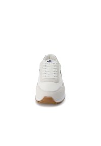 Sneaker bianco con tomaia in suede e pelle testurizzati, chiusura con lacci e suola in gomma naturale. Presenta un logo discreto vicino ai lacci.