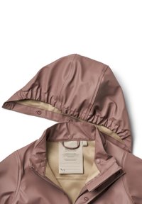 Veste de pluie marron amovible avec capuche, doublure intérieure beige, fermeture éclair, boutons-pression et une étiquette à l’intérieur du col.
