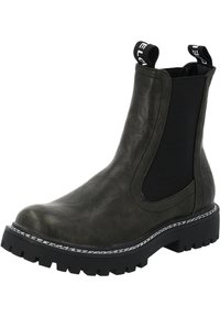 Botín Chelsea negro con parte superior de cuero texturizado, paneles laterales elásticos y suela de goma gruesa con un detalle de costura blanca en contraste.
