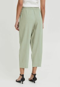 Pantalons cropped confortables de couleur vert clair, avec une taille élastique et des poches latérales. Fabriqués en tissu doux et respirant.