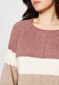 Knit sweater featuring horizontal stripes in mauve, cream, and light brown; round neckline and soft, textured fabric.